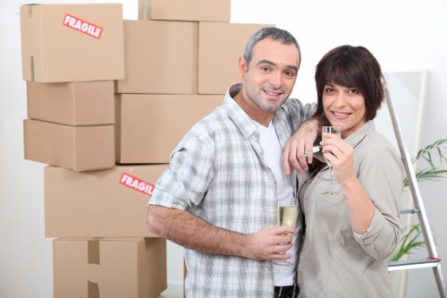 Professional movers carrying furniture through a flat corridor in Gipsyhill